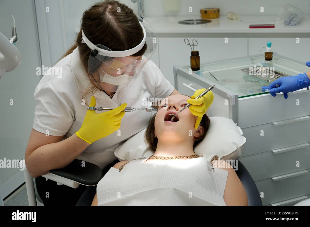 dental clinic, dental treatment, pain relief, giving an injection with a syringe to a young girl