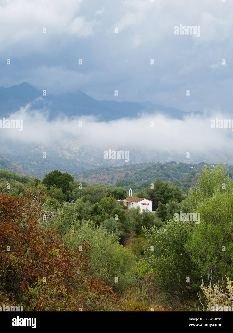 White painted chapel church in low clouds viewed from roads through White Mountains, know as Lefka Ori, Crete. Stock Photo