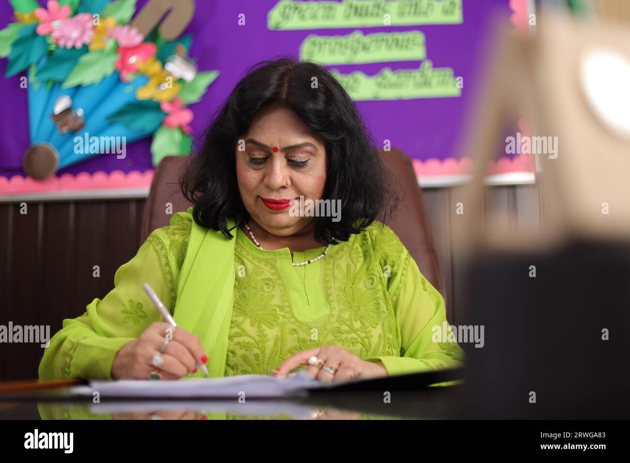 Principal mam signing a contract, agreement for the progress of the students in her school, educational progress. Stock Photo