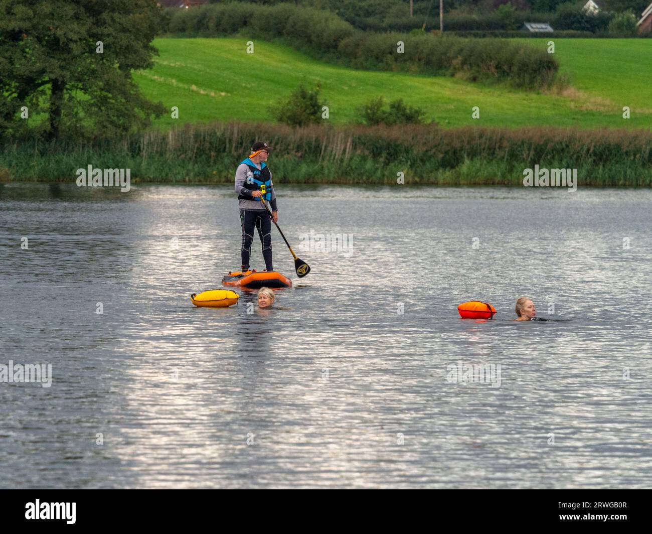 Pickmere, Knutsford, Cheshire, UK. September 14th 2023. Safety guy on paddlebioard at the end of the season wild water swimming One or Two mile race o Stock Photo