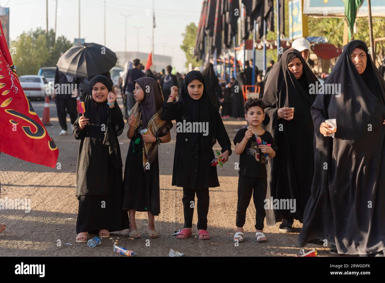 Najaf, Iraq. 3rd Sep, 2023. Iraqi Shia girls shout religious slogans as Shia Muslim pilgrims march from Najaf towards Shrine city of Karbala. Every year, millions of Shia Muslims and some from other faiths undertake a 20-day pilgrimage on foot from various cities in Iraq and Iran to the holy city of Karbala. This pilgrimage is in remembrance of Imam Hussein, the grandson of the Prophet Muhammad, who died in a battle in 680 AD. On the 40th day of mourning for Hussein, known as Arbaeen, pilgrims converge in Karbala to pay tribute at his shrine. Along the way, volunteers provide food, water, Stock Photo
