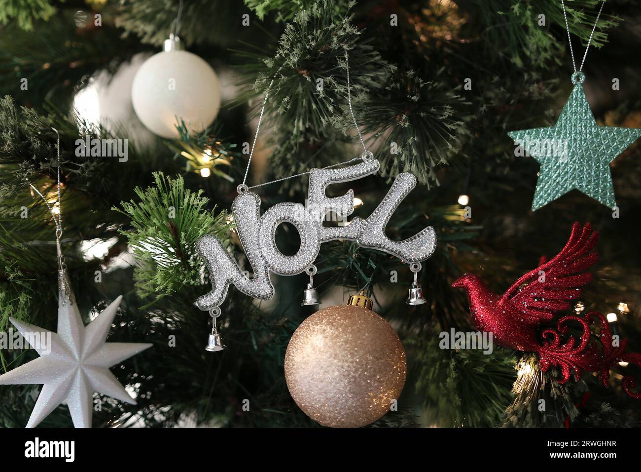 Noel, Dove, Stars and Baubles Decorations on the Christmas Tree Stock Photo