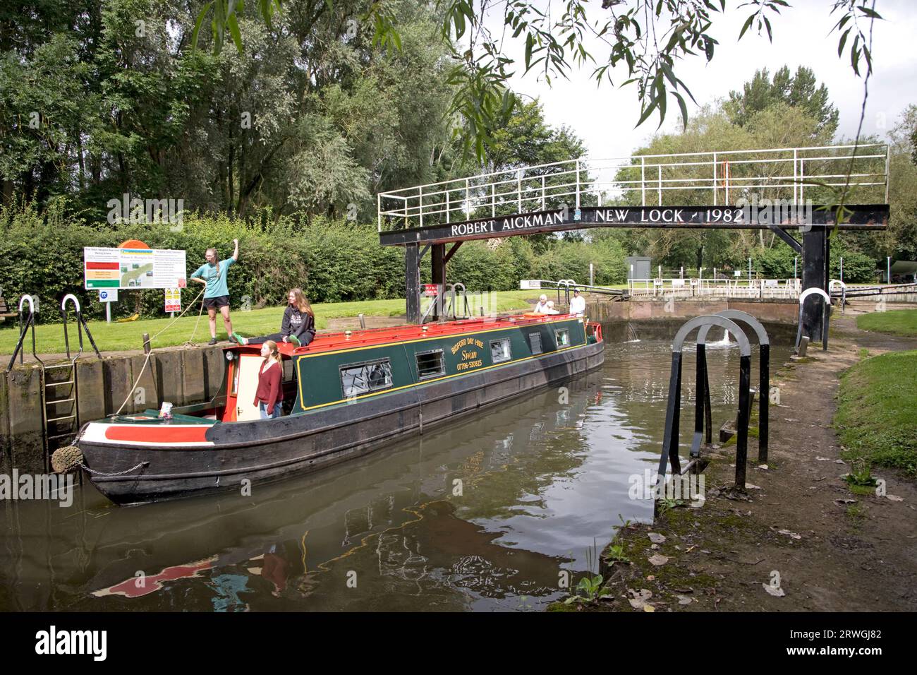 Young holiday makers on barge approaching Robert Eichman bridge and lock on River Avon near Offenham UK Stock Photo