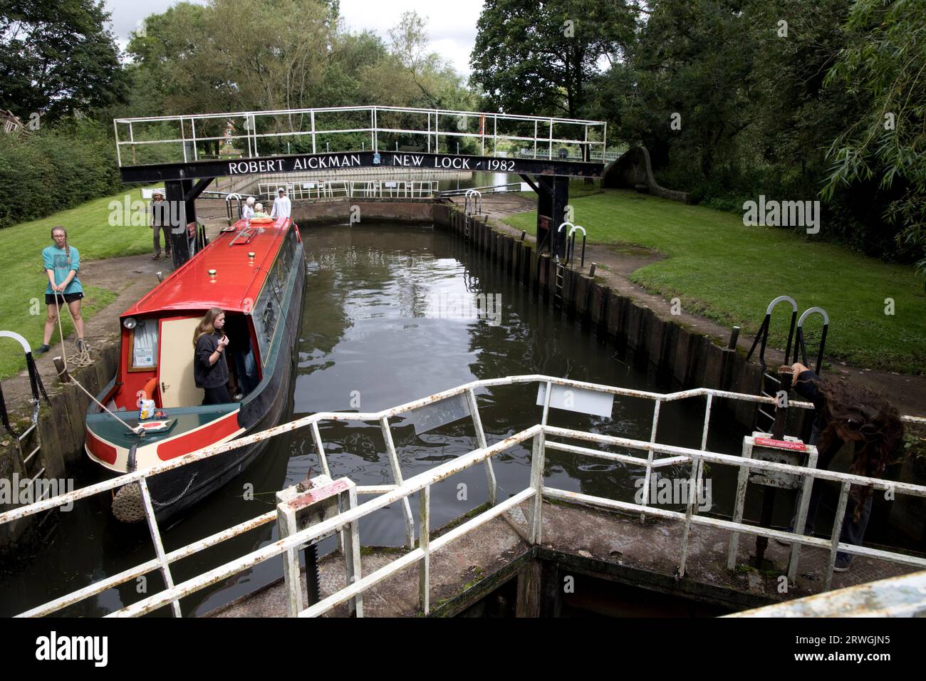 Young holiday makers on barge negoptiating lock by Robert Eichman bridge  River Avon near Offenham Worcestershire UK Stock Photo