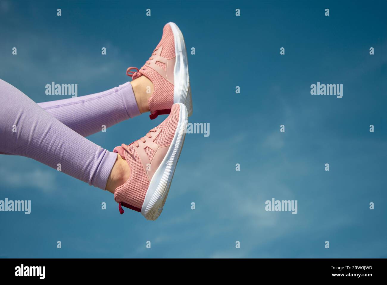 close up of pink trainers against a blue sky background, fitness concept Stock Photo