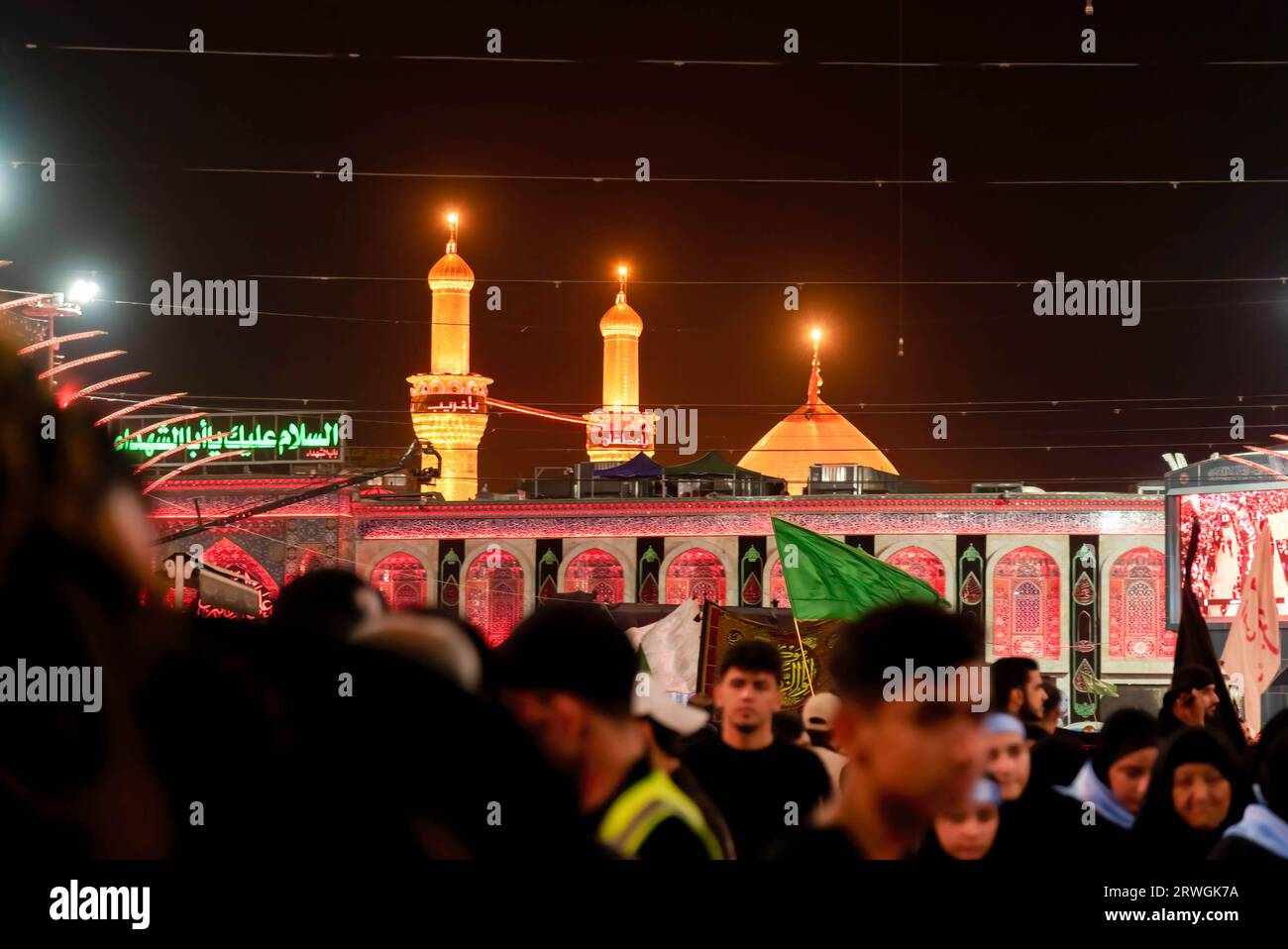 View of Shrine of Imam Hussein on Arbaeen day in Karbala. Every year, millions of Shia Muslims and some from other faiths undertake a 20-day pilgrimage on foot from various cities in Iraq and Iran to the holy city of Karbala. This pilgrimage is in remembrance of Imam Hussein, the grandson of the Prophet Muhammad, who died in a battle in 680 AD. On the 40th day of mourning for Hussein, known as Arbaeen, pilgrims converge in Karbala to pay tribute at his shrine. Along the way, volunteers provide food, water, and shelter, and villagers open their doors to the pilgrims. Stock Photo
