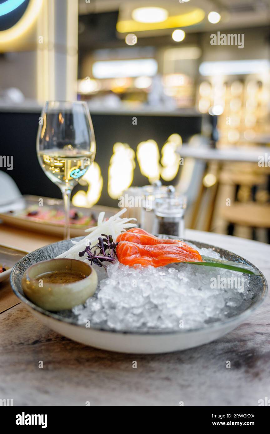 Salmon sashimi plate with sauce and ice on a marble table in a restaurant Stock Photo