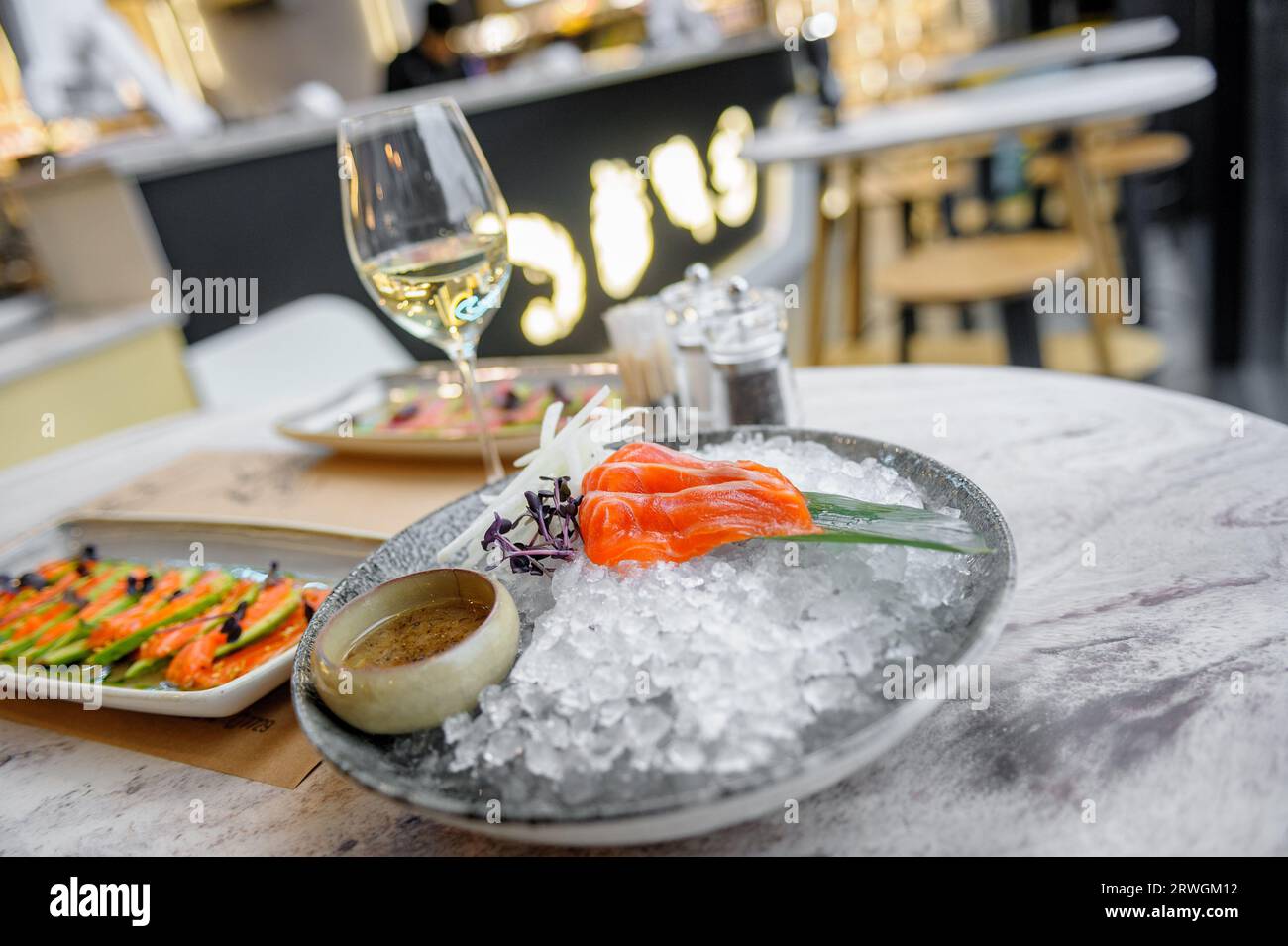 Salmon sashimi plate with sauce and ice on a marble table in a restaurant Stock Photo