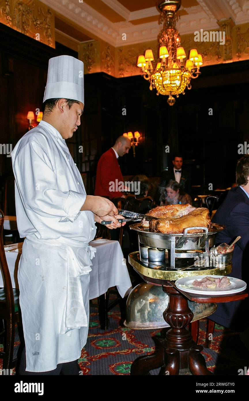 Carver carving meat at the table in Simpson's in the Strand restaurant, attached to the Savoy Hotel. Historic main dining room. Classic British club Stock Photo