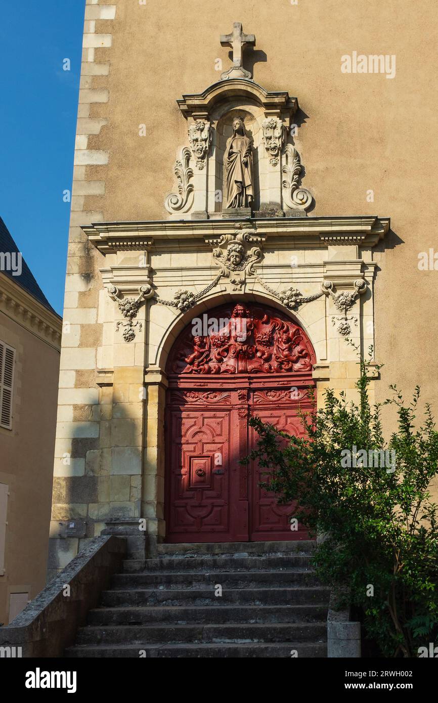 Angers, France, 2023. The sculpted red door of the chapel of the 17th century Ursuline Convent (couvent des Ursules) in the old town (vertical) Stock Photo