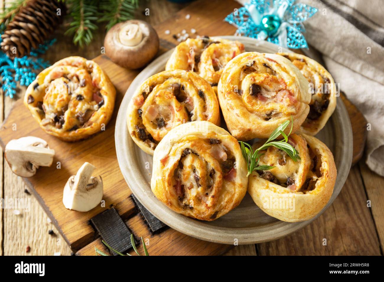 Italian appetizers. Pizza rolls puff pastry stuffed with prosciutto bacon, mushrooms and cheese on the Christmas table. Stock Photo