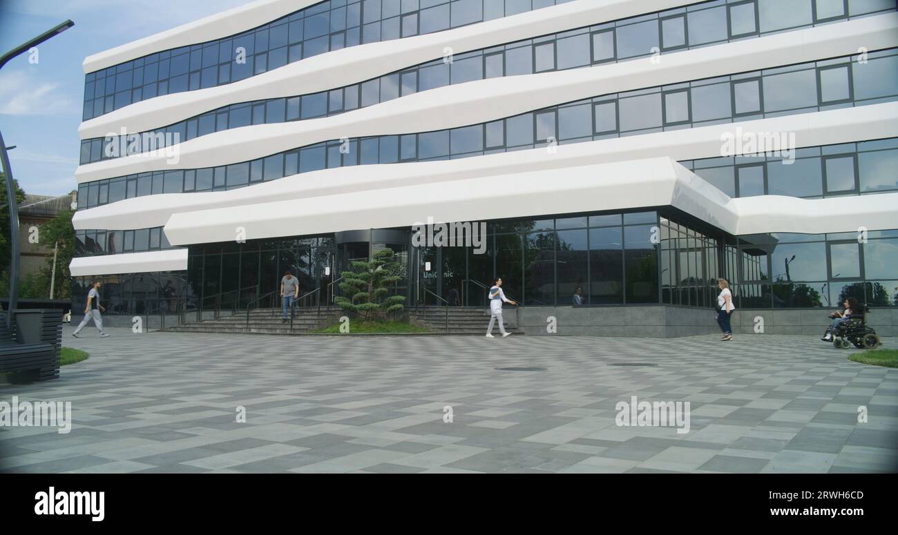 Courtyard of modern medical facility. Medical staff and diverse people