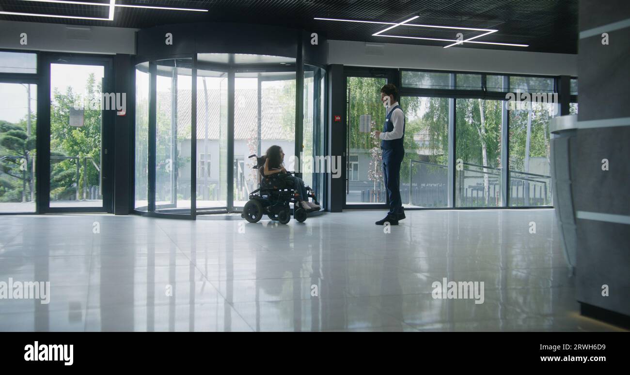 Woman with SMA disability rides in clinic entrance on motorized