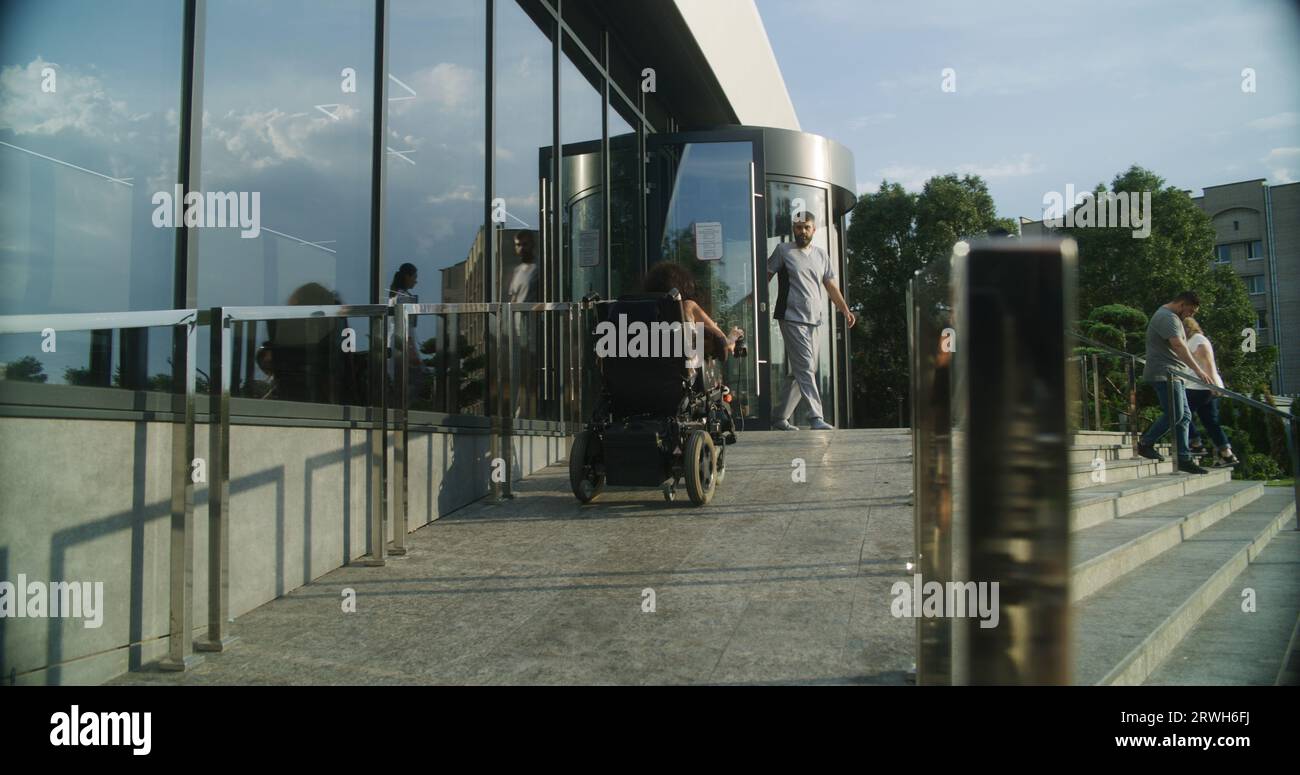 Woman with physical disability rides into clinic entrance on motorized