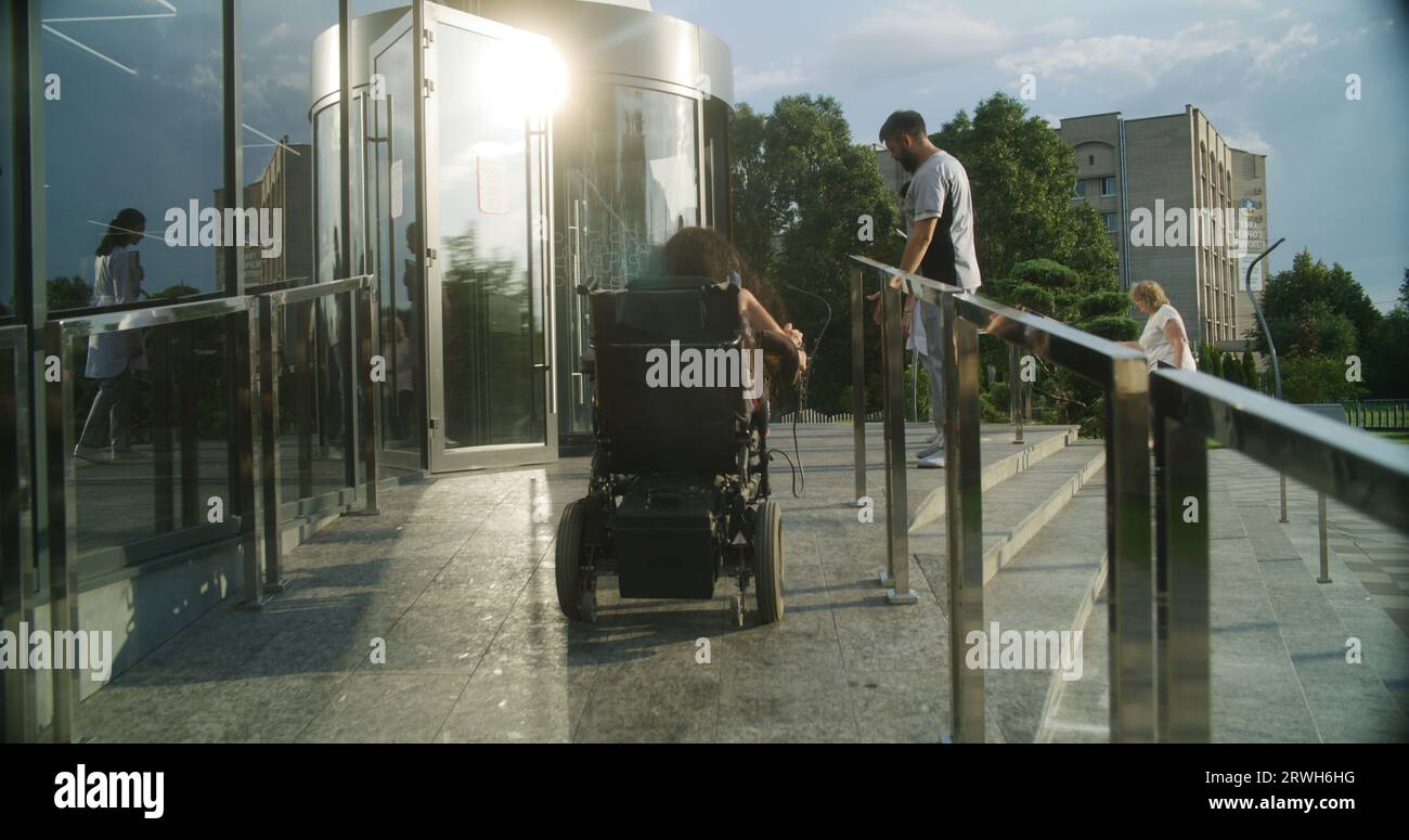 Woman with physical disability rides into clinic entrance on motorized