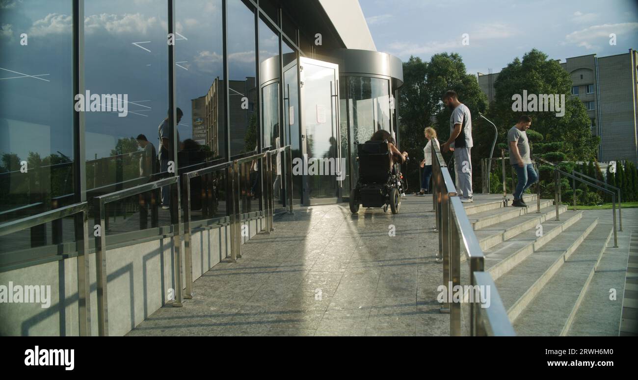 Woman with physical disability rides into clinic entrance on motorized