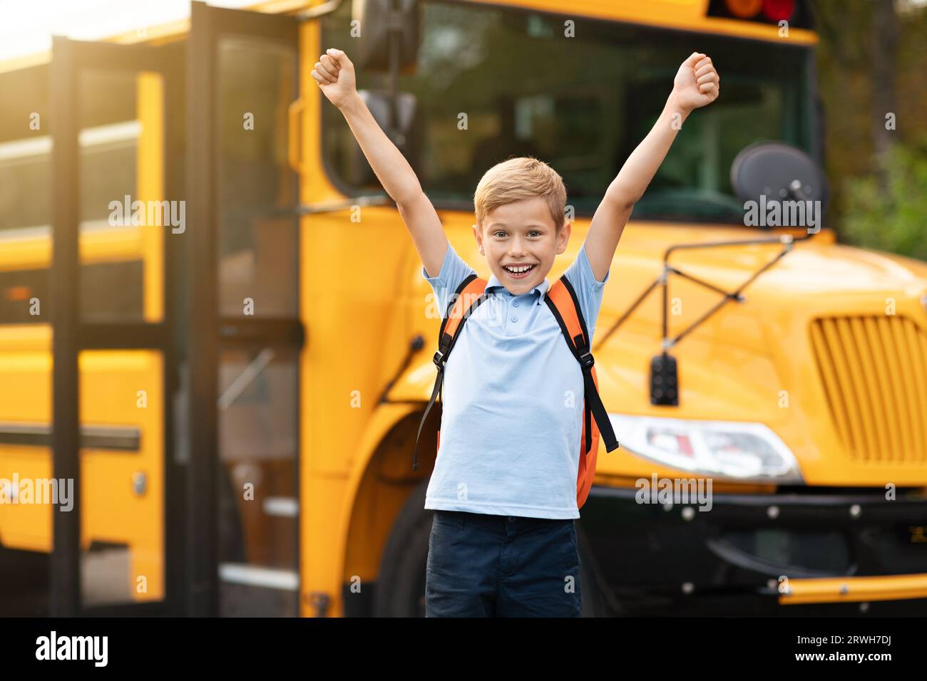 Back To School. Happy Boy Jumping Near Shool Bus And Raising Hands