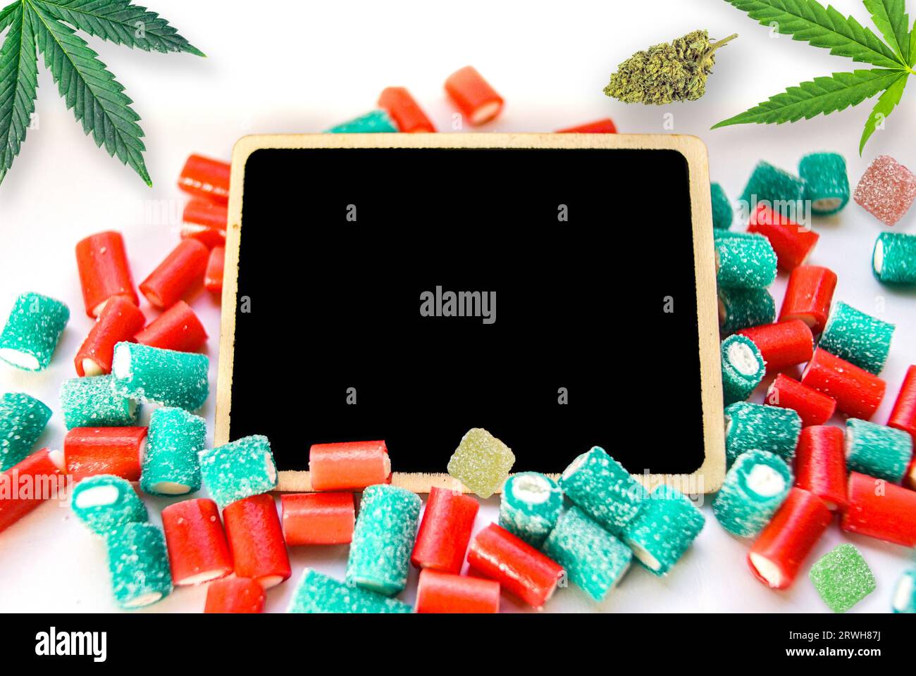 Cannabis products flat lay buds and gummy candies on chalk board with copy space Stock Photo
