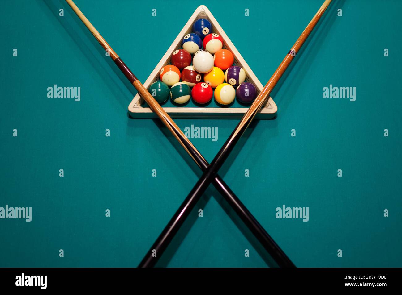 Billiard accessories balls and crossed cues on a billiard table Stock Photo