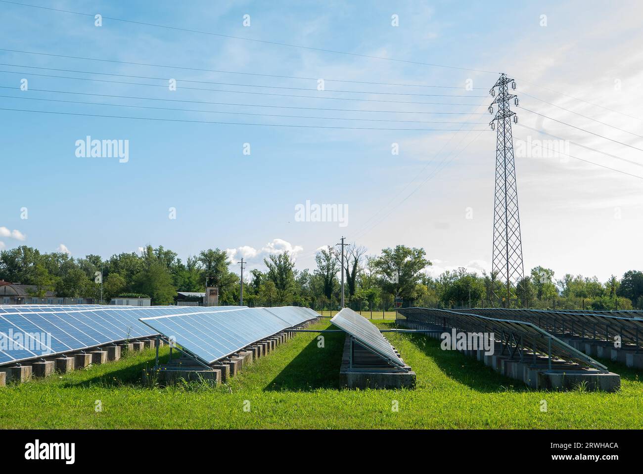 Lines of solar panels of a wide power generation plant on a green field in northern Italy Stock Photo