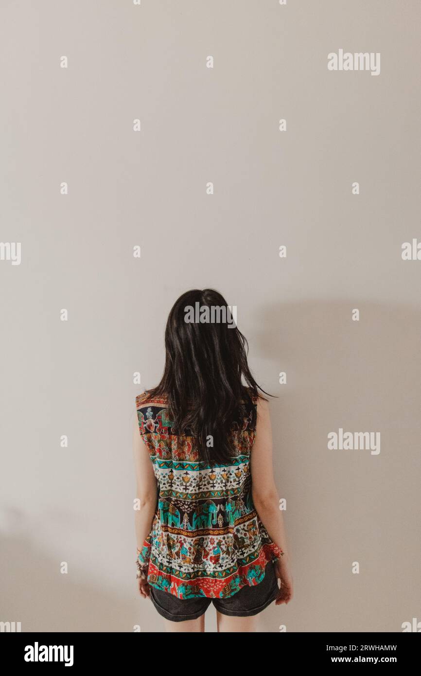 young woman with her back to white background Stock Photo Alamy