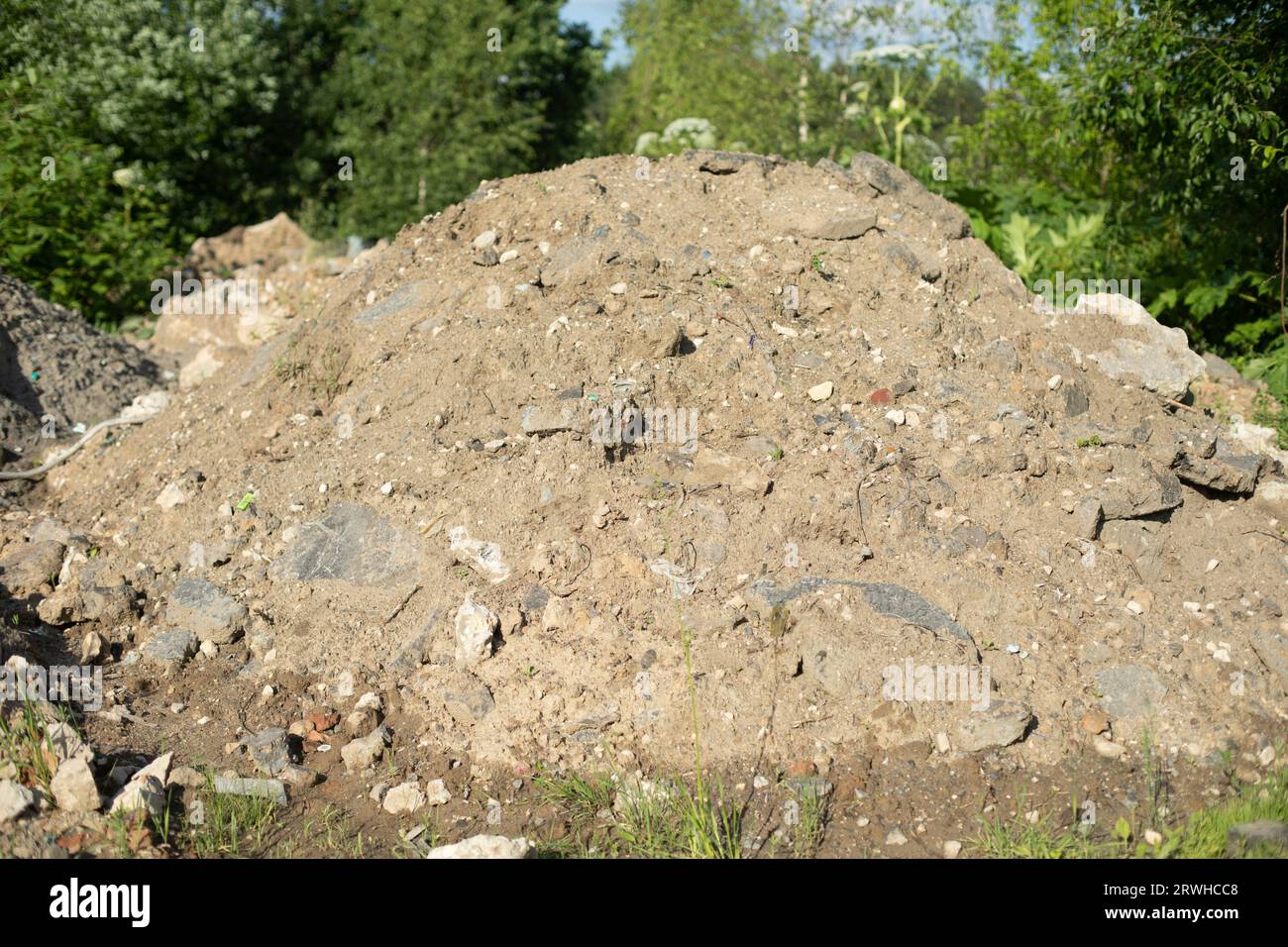 Mountain of construction debris. Excavated earth. Discarded cement. Illegal garbage dumping. Stock Photo