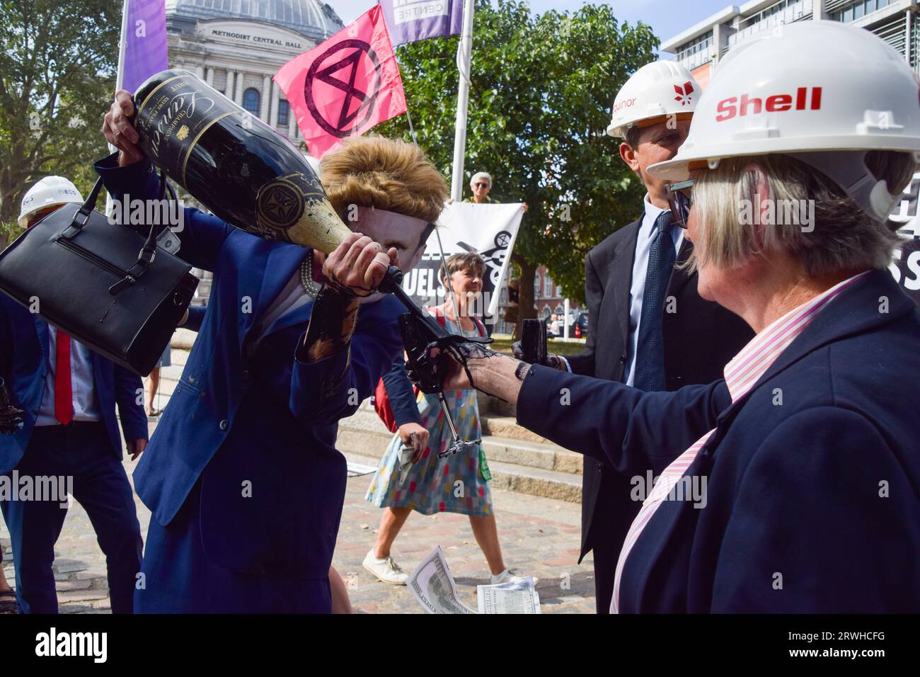 London, UK. 16th September 2023. Protesters dressed as executives from fossil fuel companies and Labour Party leader Keir Starmer pour fake oil from a champagne bottle as Extinction Rebellion stage a protest against new fossil fuels. Stock Photo