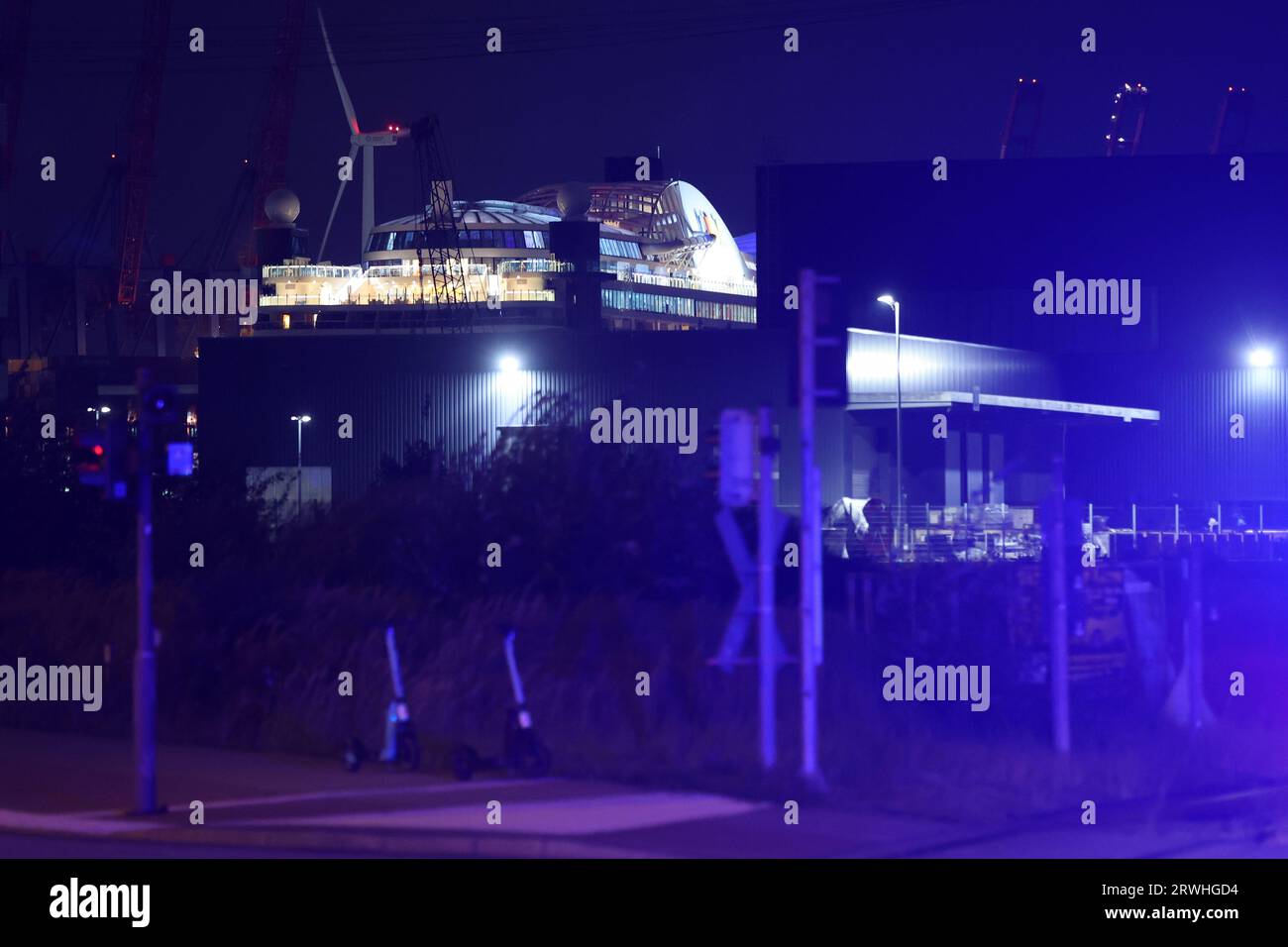 Hamburg, Germany. 19th Sep, 2023. Parts of the cruise ship 'Aidaperla' can be seen in the evening at Cruise Center Steinwerder. The blue light of a patrol car can also be seen in the picture. A 1,000-pound bomb of English design from World War II was found on Tuesday during dredging work in the port of Hamburg. It was to be defused on site later that evening, according to a spokesman for the Hamburg Fire Department. Credit: Bodo Marks/dpa/Alamy Live News Stock Photo