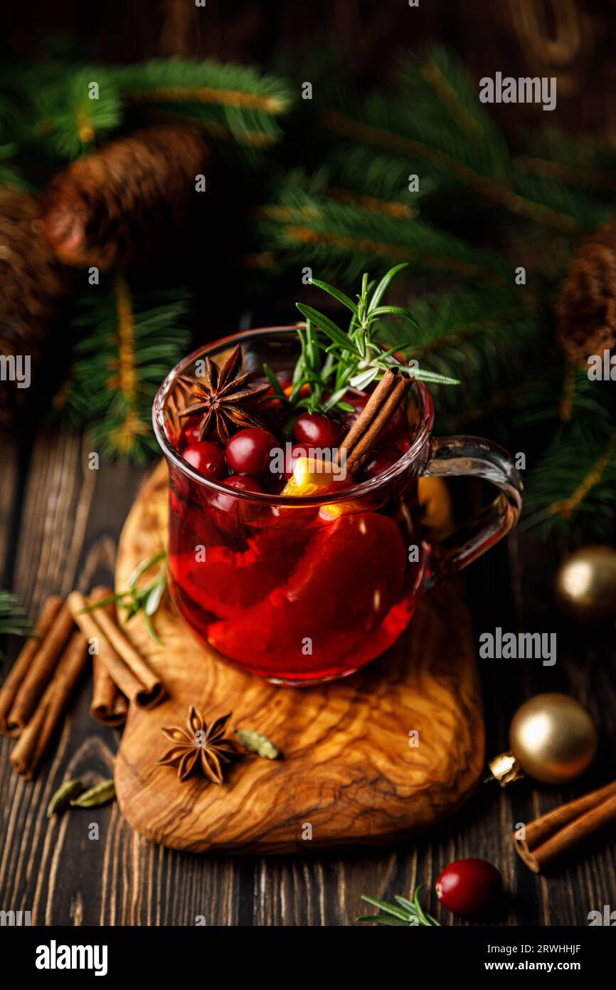 Christmas mulled wine with cranberry, orange, cinnamon, anise and rosemary. Traditional hot drink or beverage, festive Xmas or New Year winter cocktail Stock Photo