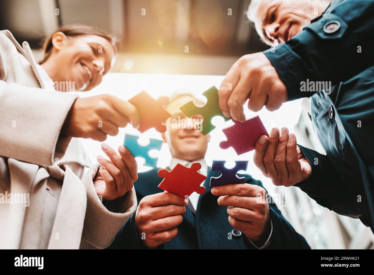Businessmen working together to build a puzzle as teamwork, partnership ...