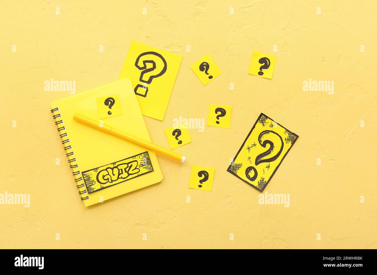 Notebook with quiz cards and question marks on yellow background Stock