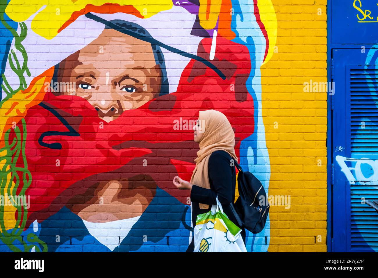 a-young-woman-walks-past-some-colourful-street-art-shoreditch-london