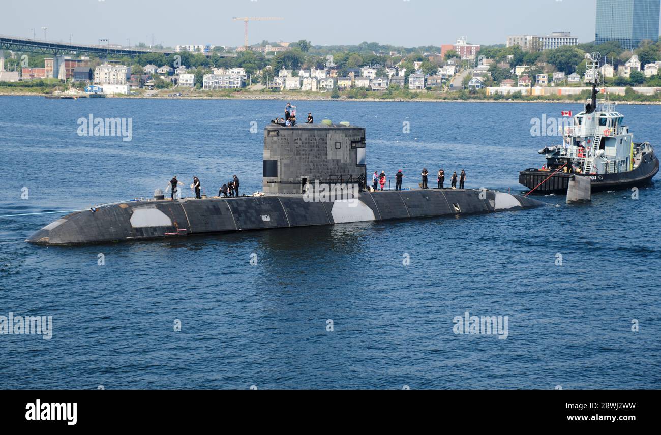 HMCS  Windsor, leaving the Halifax Navy Base with crew watching while being tugged out Stock Photo