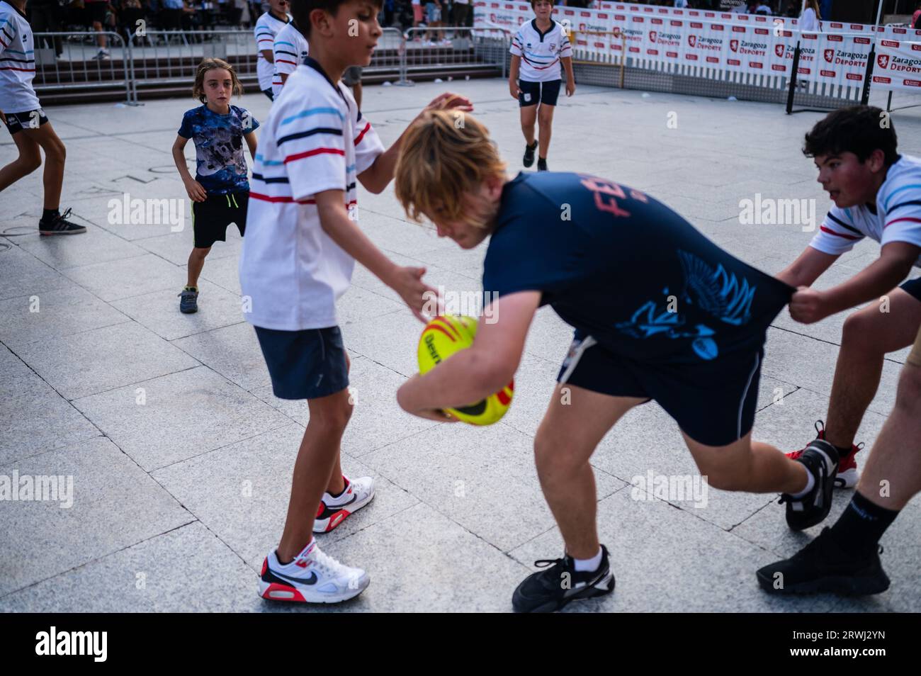 Kids trying rugby during Sports Day multi-sports street event in Plaza del Pilar, Zaragoza, Spain Stock Photo