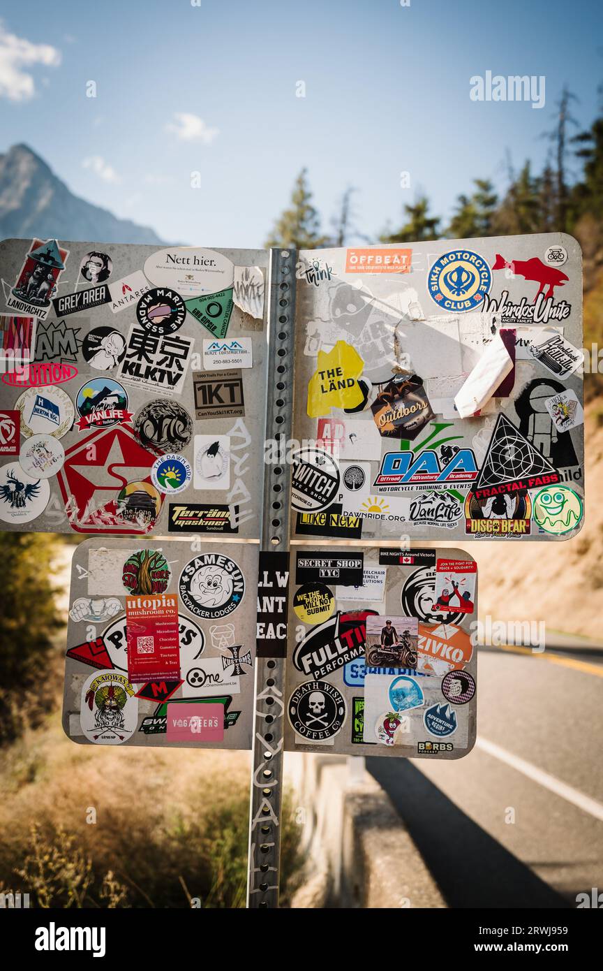 A roadsigns covered with stickers and decals.  The Duffy Lake road, between Lillooet and Pemberton BC, Canada. Stock Photo