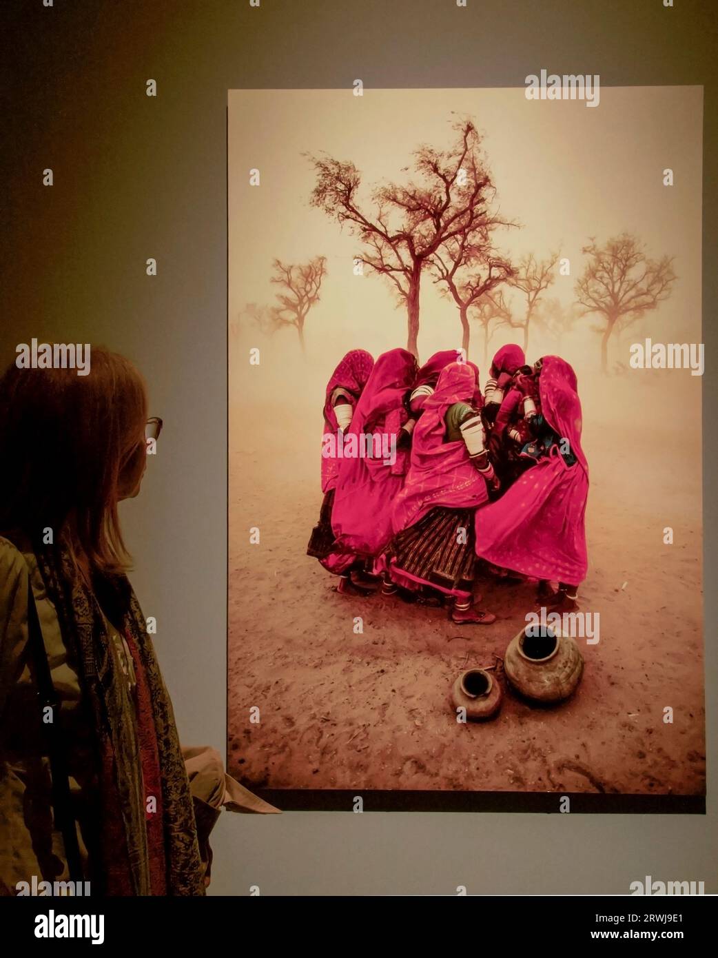 A woman looks at a photograph by American Photojournalist Steve McCurry Stock Photo