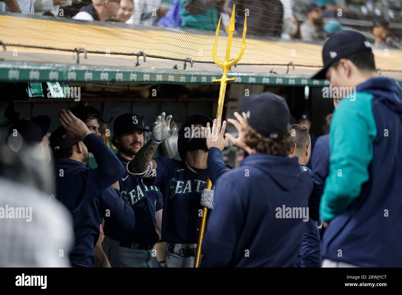 Seattle Mariners' Teoscar Hernandez holds a trident in the dugout after  hitting a solo home run Kansas City Royals during the second inning of a  baseball game, Sunday, Aug. 27, 2023, in