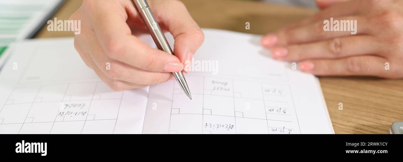 Business woman checks her planner and takes notes in organizer Stock ...