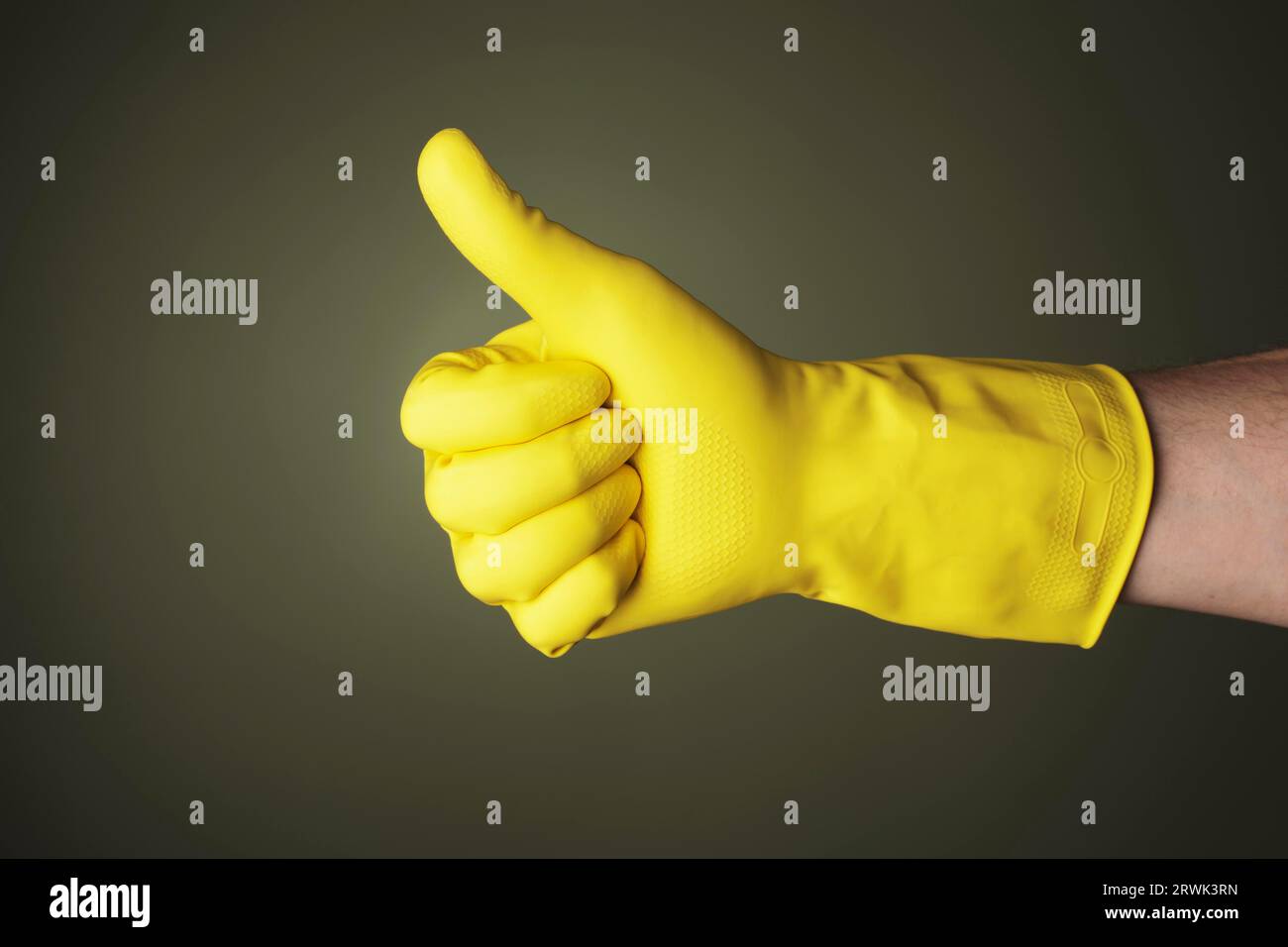 A hand wearing a yellow protective rubber glove does Stock Photo - Alamy
