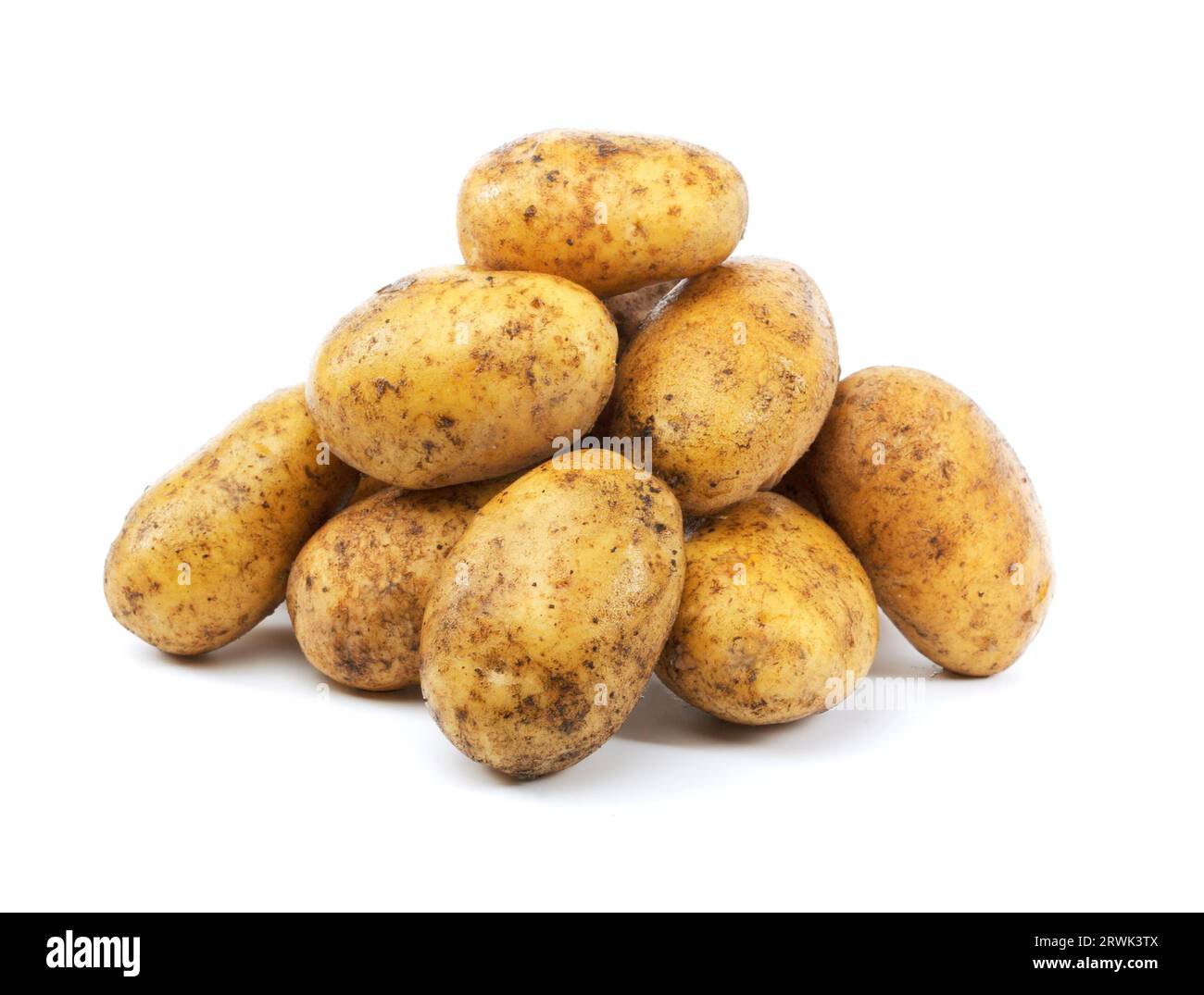 A Heap of harvested dirty potatoes on white Stock Photo