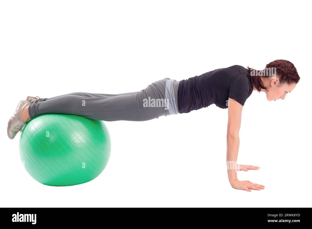 Young woman with gym ball doing pushup exercise, isolated on white background Stock Photo