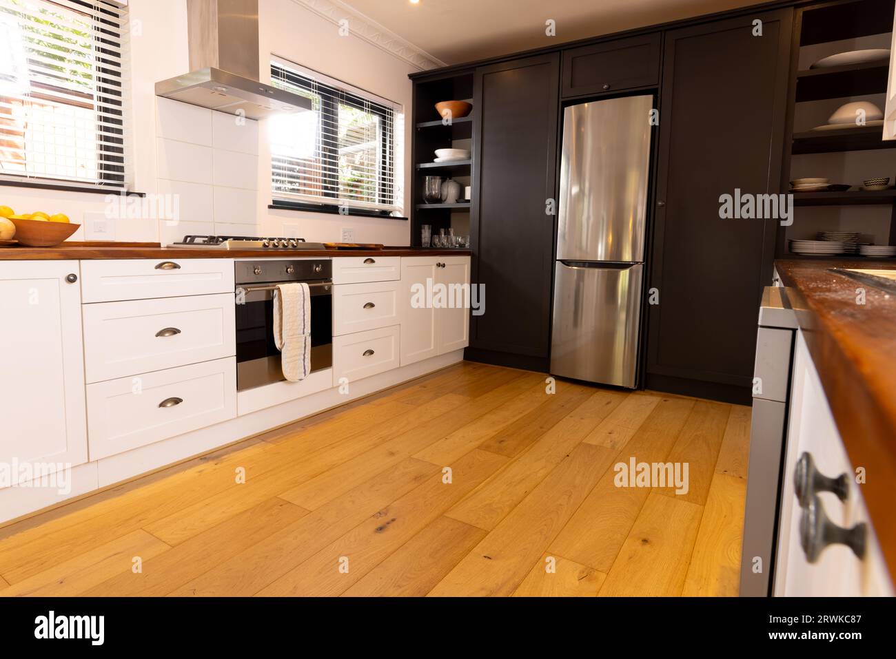 Spacious, modern kitchen with household appliances and wooden floor Stock Photo