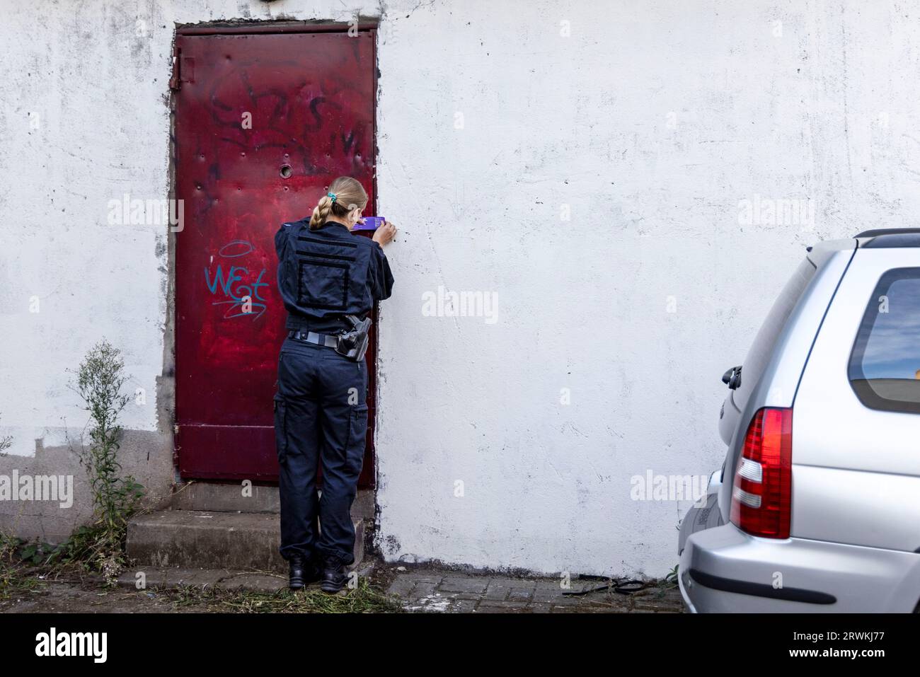 Duisburg, Germany. 20th Sep, 2023. A policewoman seals the door to a searched storage room in a backyard in downtown Duisburg. In a large-scale operation against organized drug crime, houses, apartments and business premises were searched on Thursday morning, mainly in North Rhine-Westphalia. In addition, there had been an operation in southern Schleswig-Holstein. Credit: Christoph Reichwein/dpa/Alamy Live News Stock Photo