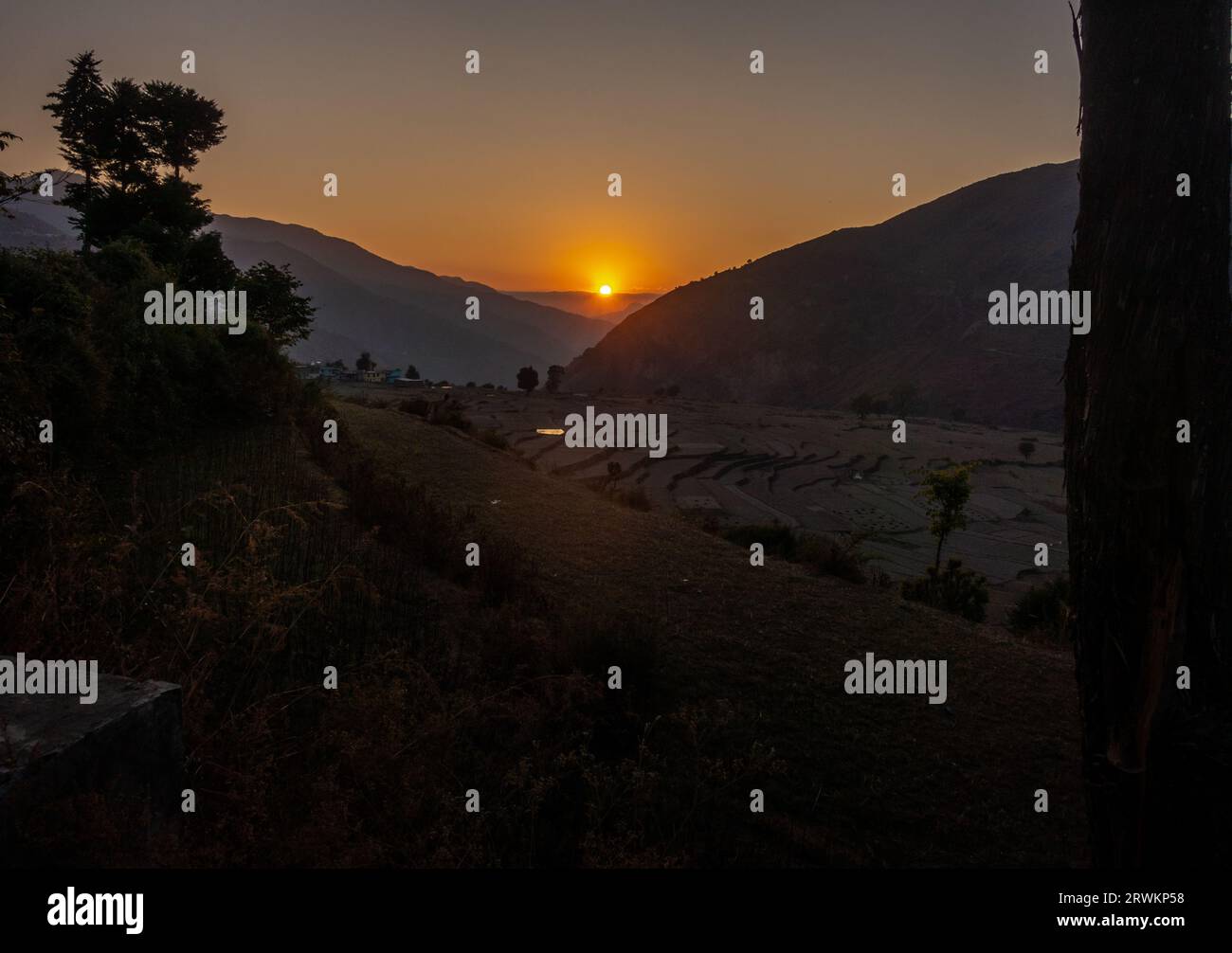 Gorgeous golden hour sunset in Uttarakhand's Himalayan Nag Tibba, featuring a round sun at its center Stock Photo