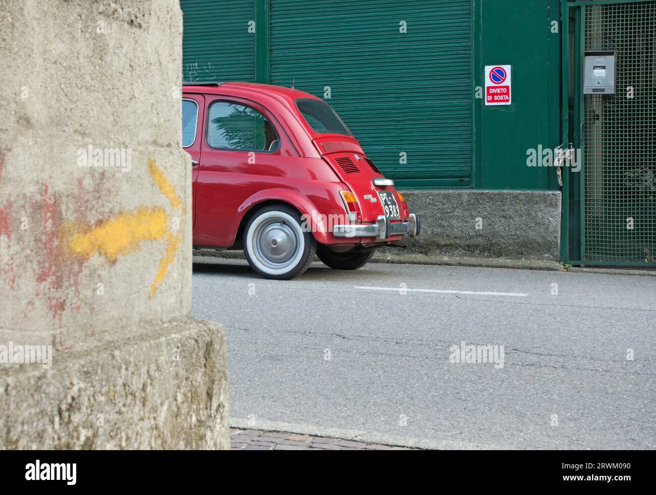 a red Fiat 500 parked on the street in front of a No Stopping sign ...