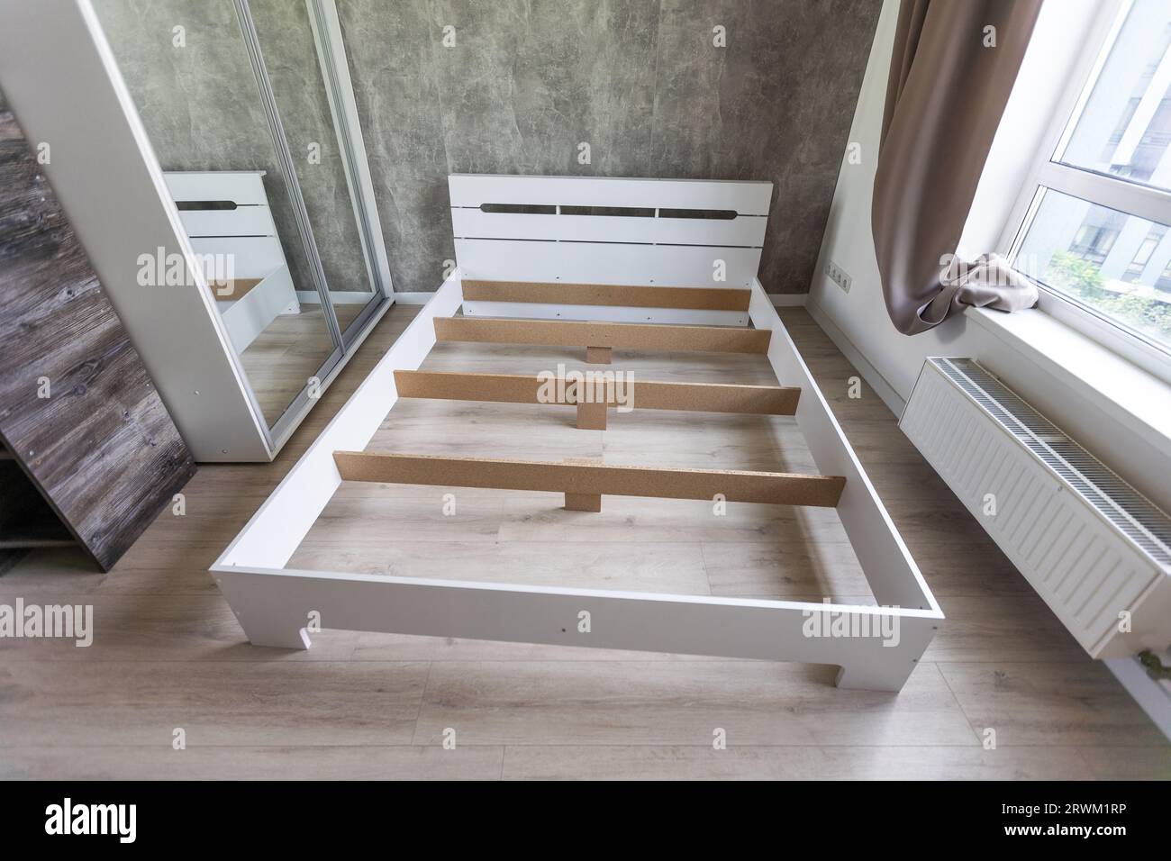 The furniture assembler assembles the bed frame, do it yourself and assemble new furniture Stock