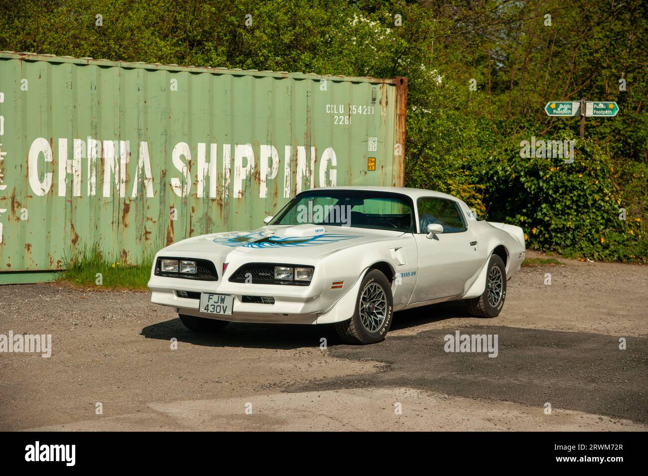 White Pontiac Firebird Trans-Am parked by a shipping container Stock Photo