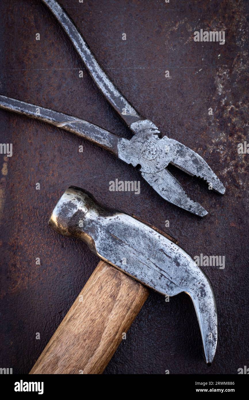 Old hammer and pliers on an iron rusty background Stock Photo