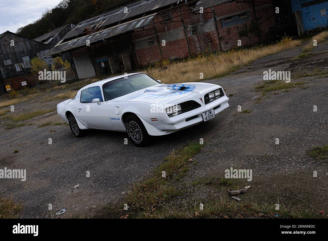 White Pontiac Firebird Trans-Am parked in a derelict industrial setting on a winter's day Stock Photo