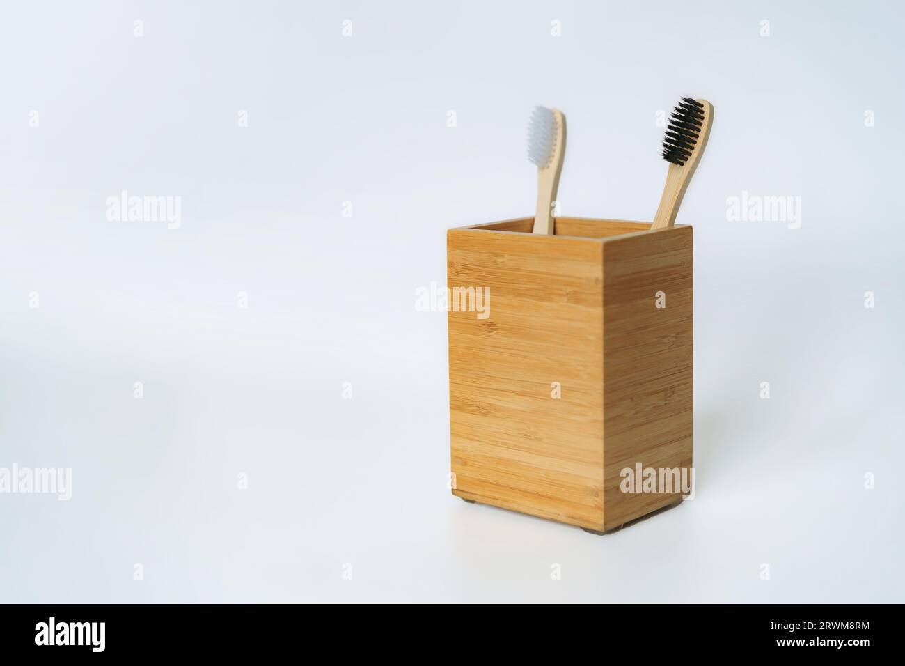two toothbrushes in bamboo holder on white background. Eco friendly ...